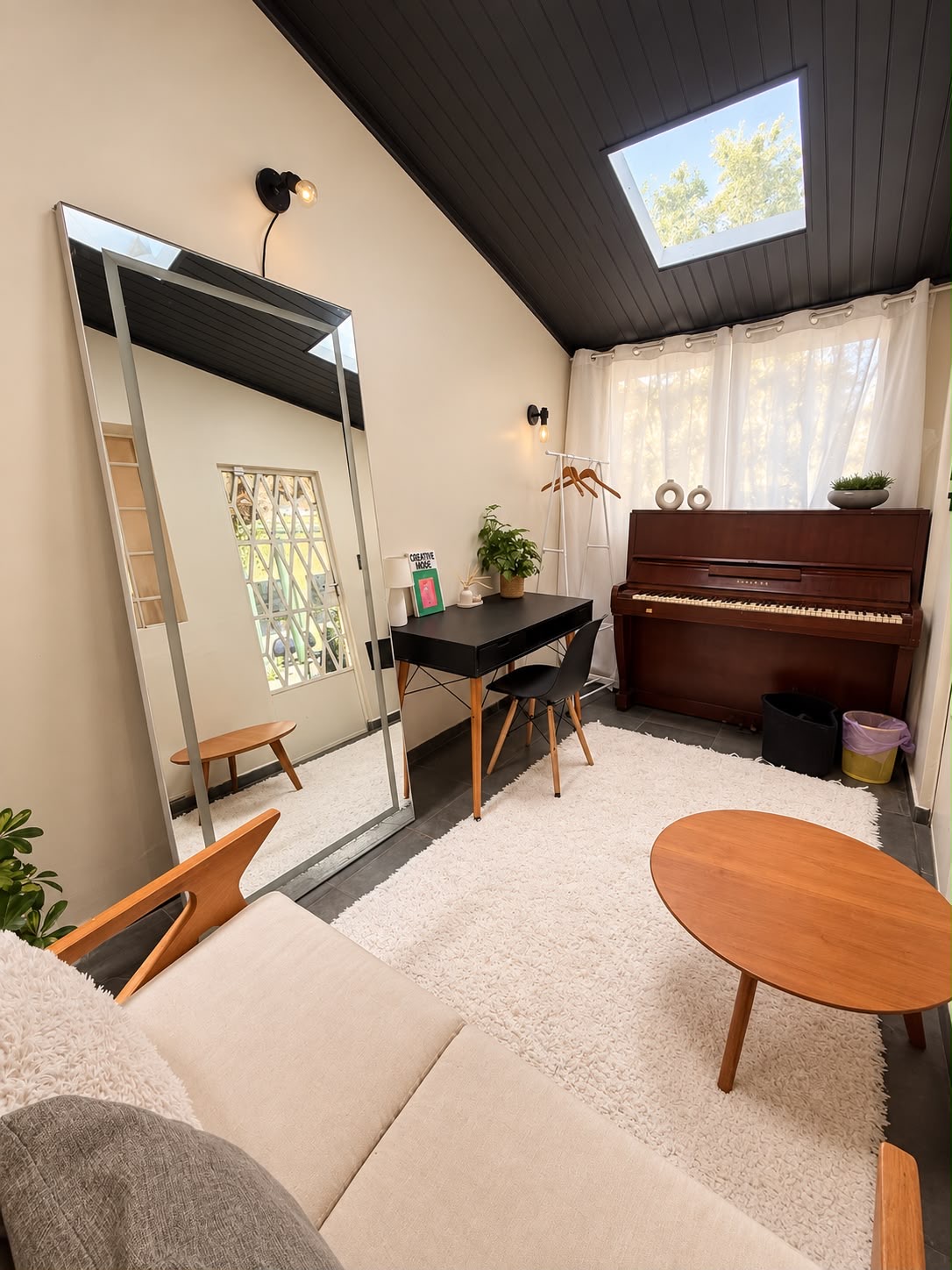 Camarim da Eixo Criativo com espelho, arara de roupas, bancada e piano.
