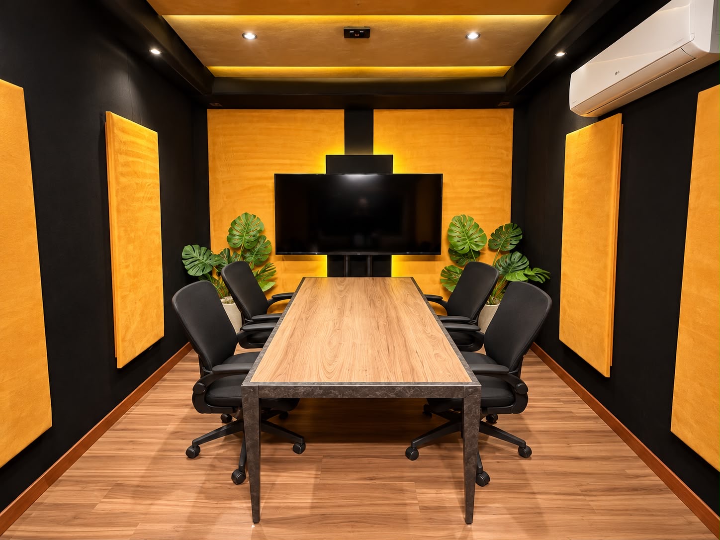 Estúdio de podcast Eixo Criativo com mesa para quatro pessoas, monitor e painéis amarelos.